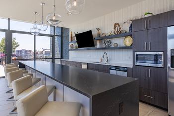 a large kitchen with a long counter and chairs